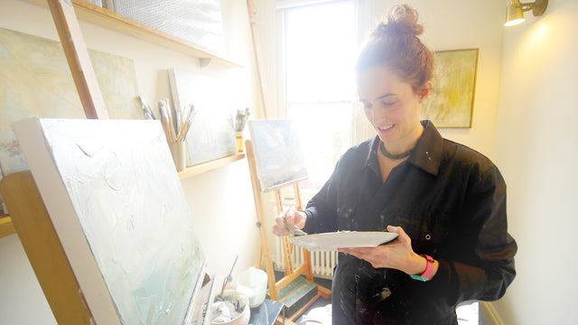 Grace Wilmshurst, artist, in her studio painting canvases.